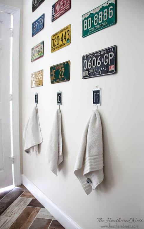 hand towels hung on hooks under vintage license plates in a kids bathroom