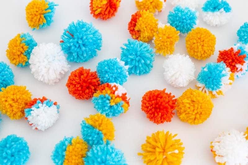 image of many brightly colored yarn pom poms 