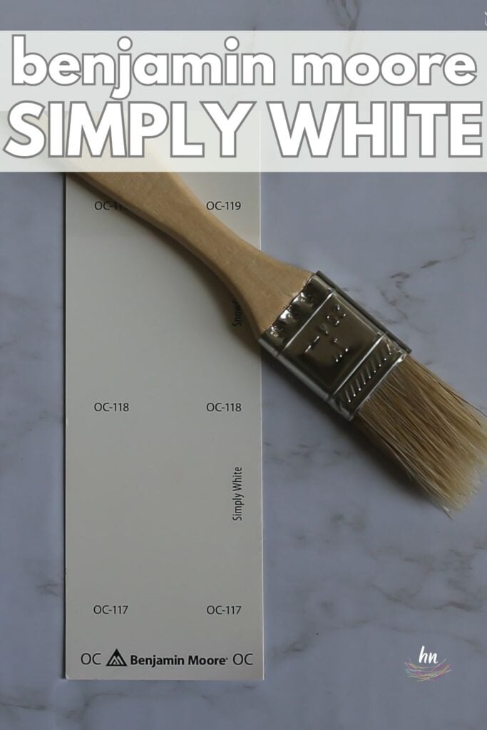 Benjamin Moore Simply White paint swatch on a marble background with a paintbrush