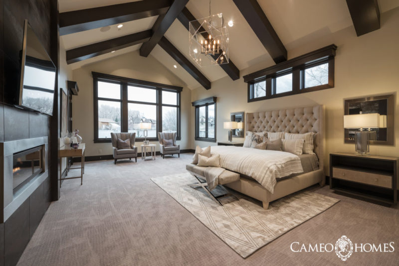 bedroom with dark ceiling beams and large bed.