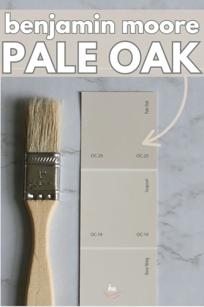 Benjamin Moore Pale Oak OC-20 paint chip card on a marble surface with wood paintbrush