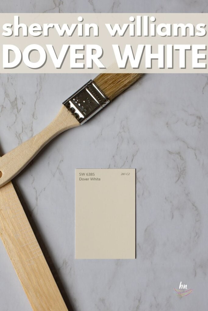 paint swatch of Sherwin Williams Dover White on a marble counter with wood paintbrush and paint stirrer