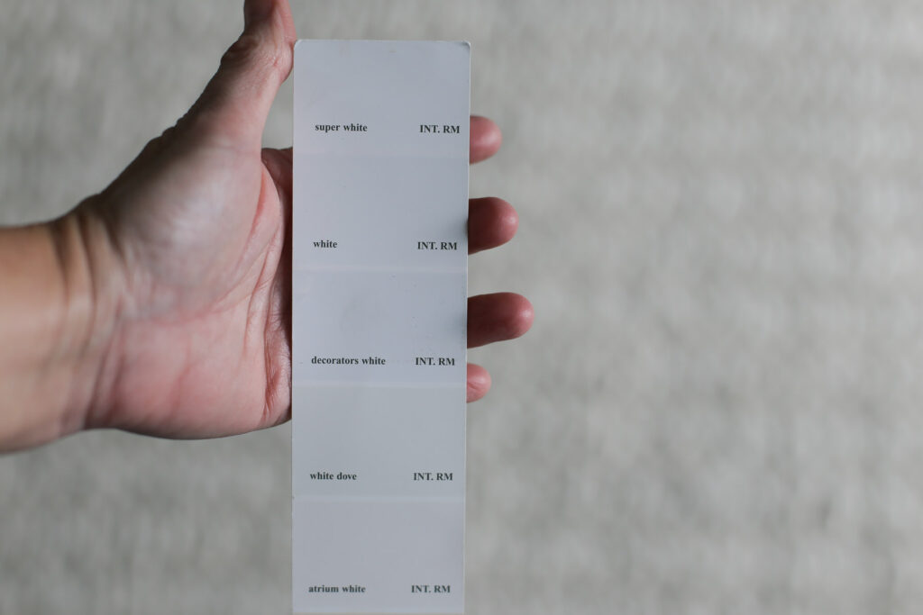 hand holding paint swatch of Benjamin Moore Super White