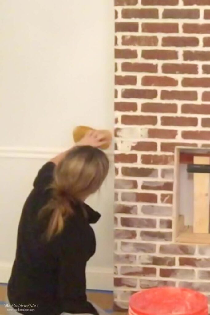 woman performing the german smear on a brick fireplace