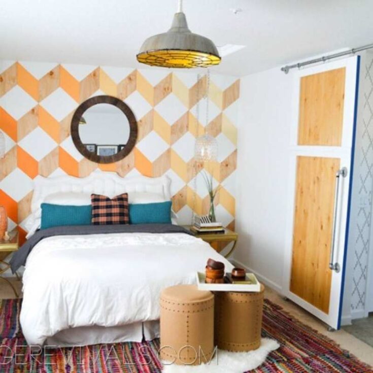 orange painted geometric accent wall behind bed
