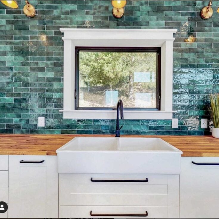 IKEA butcher block counters with white cabinetry and teal blue glass backsplash tile in a kitchen