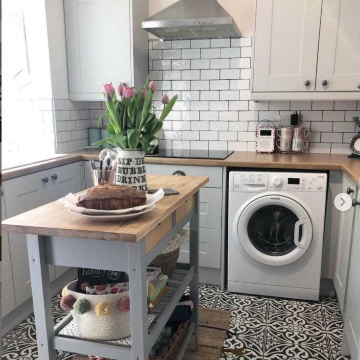 IKEA butcher block counters in a galley kitchen/laundry combo with cement tiles and subway tile backsplash