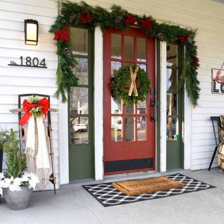 door decor for the holidays with wreath and sleigh