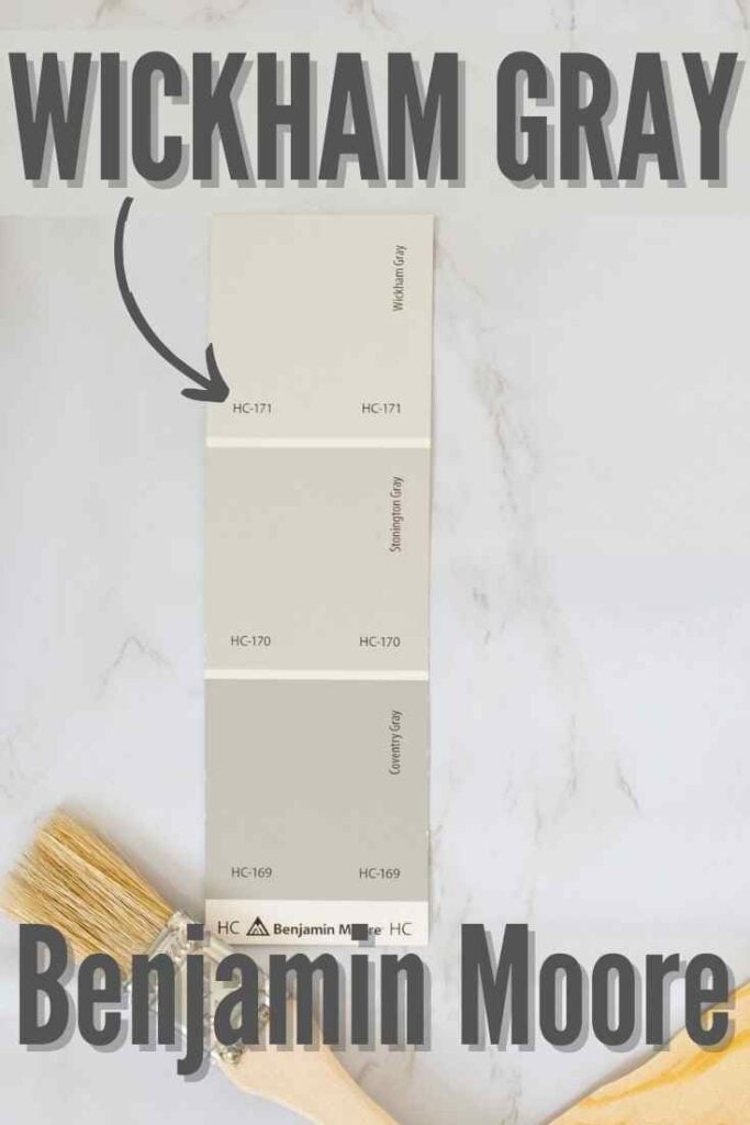 paint swatch of HC-171 Benjamin Moore Wickham Gray on a marble surface with paint brush and paint stirrer