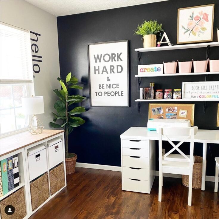 craft room with black accent wall and graphic wall art