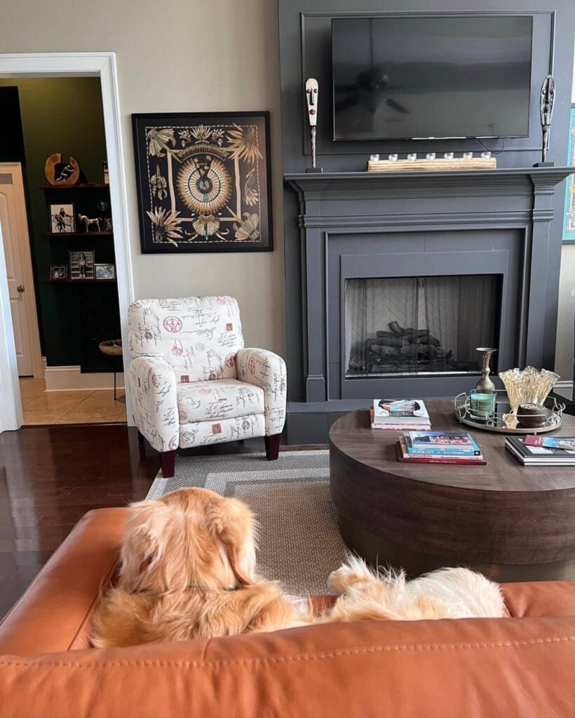 dog sits on a leather couch facing a fireplace painted in SW Urbane Bronze, and walls painted SW Balanced Beige