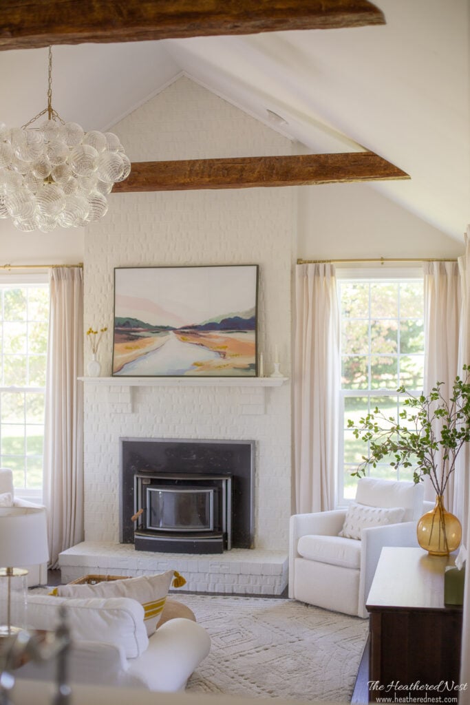 neutral family room makeover with Benjamin Moore Swiss Coffee paint, faux beams, glass bubble chandelier, white sofa with pops of yellow