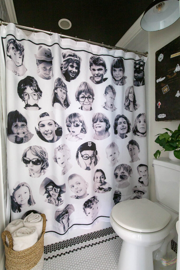 teen bathroom with black and white mosaic tile floor, black ceiling, white subway tile shower enclosure and personalized shower curtain with funny headshots of family pictures, double floating vanities, chalkboard paint walls with DIY kids chalk drawings